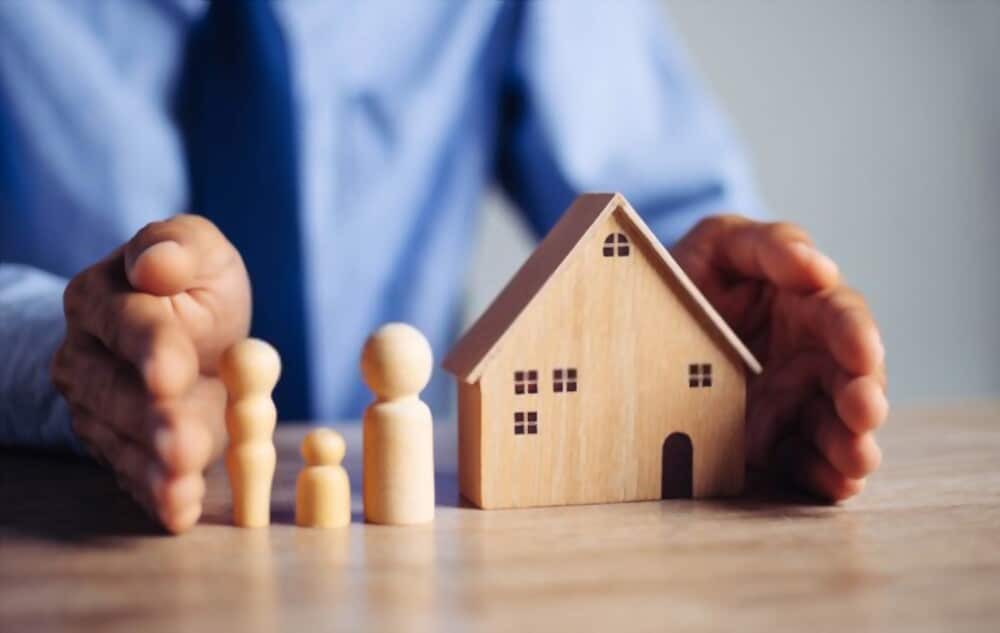 assurance habitation 2021 - homme protégeant une maquette de maison entre ses mains