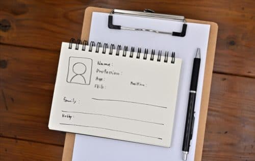 comment créer des personas ? Une note avec le personnage de l'utilisateur y est placée sur un presse-papiers, ainsi qu'un stylo.