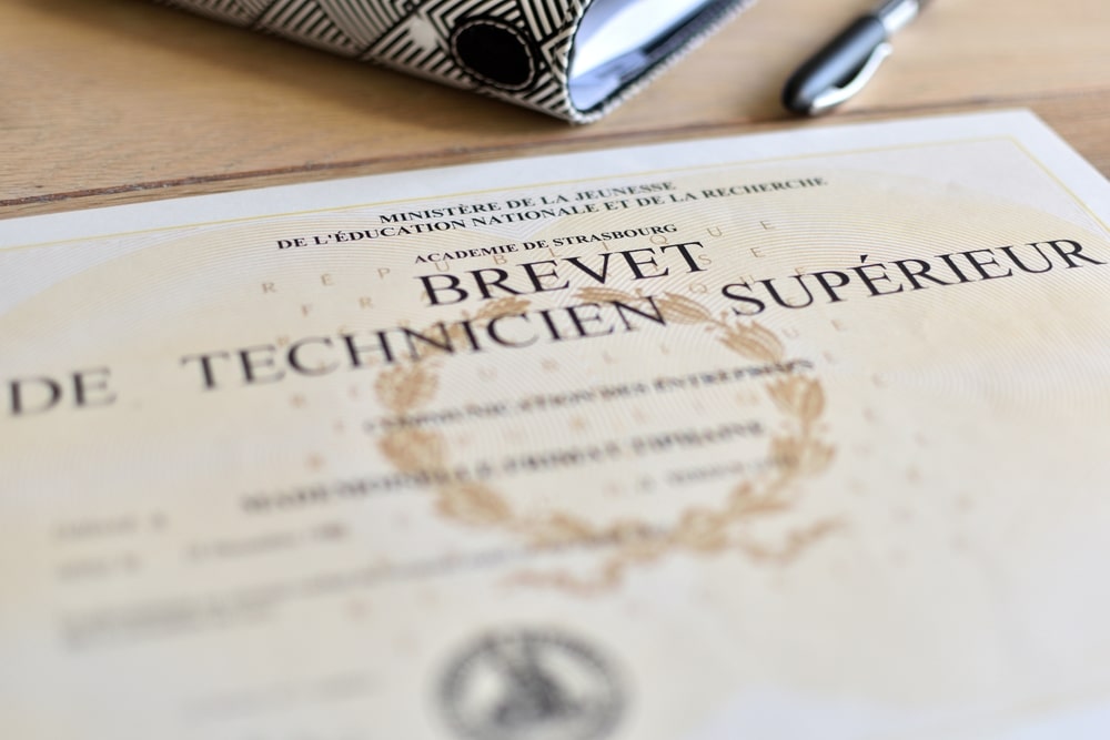 Un diplome de Bts brevet technique supérieur posé sur une table