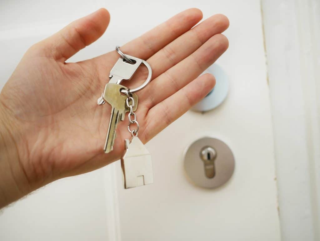 main d'homme qui tient dans sa main des clés d'un appartement en location