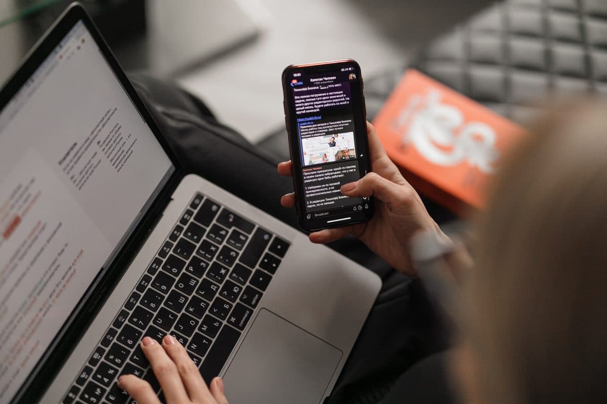 Femme faisant une recherche sur internet via son mobile et son ordinateur