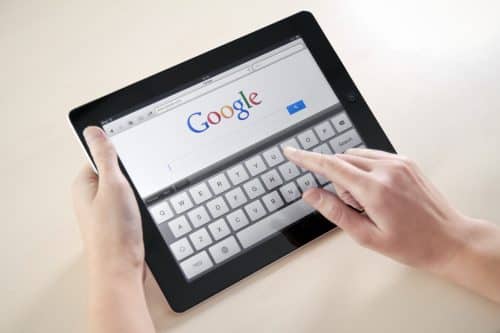 Femme faisant une recherche google sur sa tablette tactile