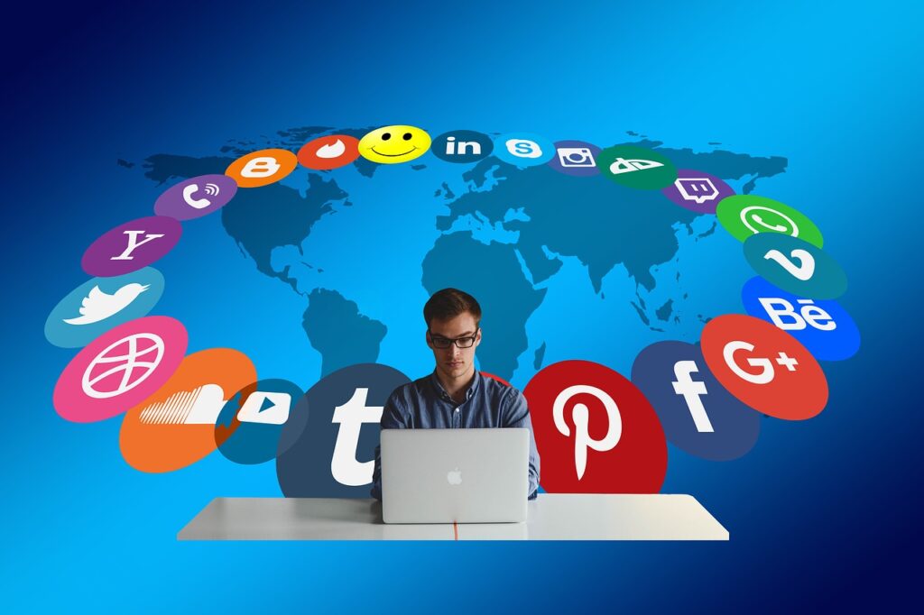 Homme écrivant sur son ordinateur entouré par les logos des canaux d'acquisition comme les réseaux sociaux et les plateformes de blogging