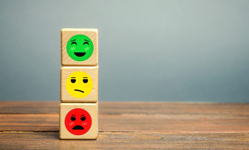 Trois cubes avec des smiley vert, jaune et rouge symbolisants les avis clients